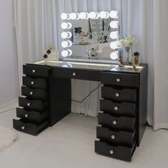 a vanity with drawers and lights on it