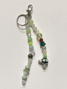 a keychain with beads and charms attached to it on a white table top