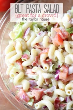 a bowl filled with pasta salad on top of a wooden table