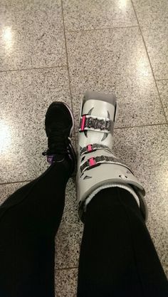 a person standing on the floor with their feet up wearing snow boots and black pants