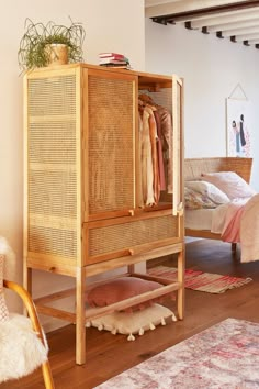 a room with a bed, chair and wicker cabinet