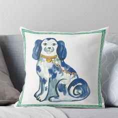 a blue and white dog with a gold collar sitting on top of a gray couch