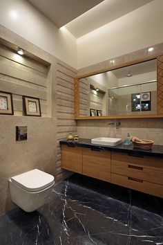 a bathroom with two sinks, a toilet and a large mirror above the vanity area