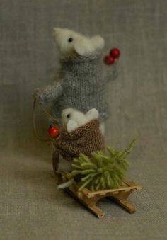 two stuffed mice are sitting on a sleigh with a christmas tree in it