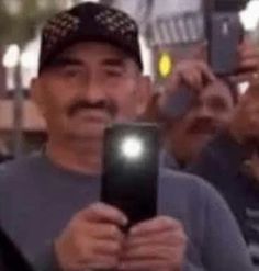 a man holding up a cell phone in front of his face