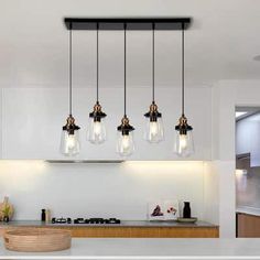 a kitchen with an island and lights hanging from the ceiling