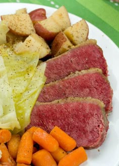 a white plate topped with meat and veggies next to a glass of beer