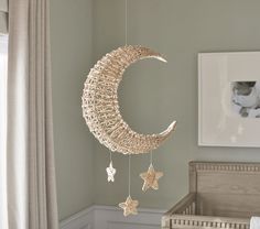 a baby crib with a moon and stars hanging from it