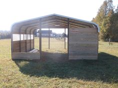 a small wooden shelter in the middle of a field