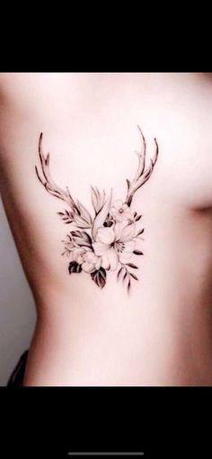 the back of a woman's stomach with flowers and antelope on it