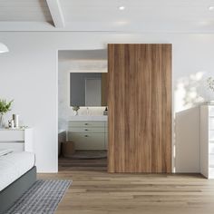 a bedroom with white walls and wood flooring next to a bed in front of a wooden door