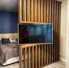 a bed room with a neatly made bed and a flat screen tv on the wall