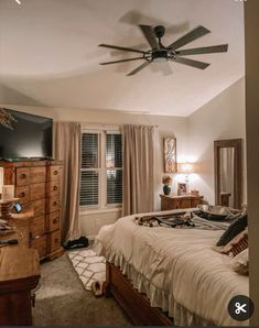 a bed room with a neatly made bed and a ceiling fan