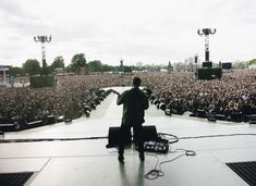 a man standing on top of a stage in front of a large group of people