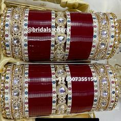 two red and gold bangles sitting on top of each other in front of a mirror