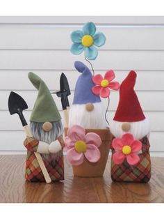 three gnome figurines sitting on top of a wooden table