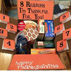 a box filled with food and candy sitting on top of a wooden table next to a sign that says, 8 reasons i'm thank you for you