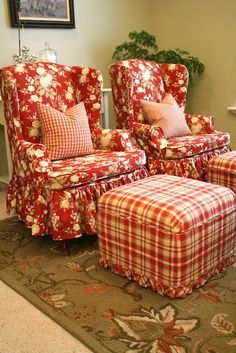 a living room with two chairs and a foot stool