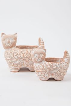 two ceramic cat planters sitting next to each other