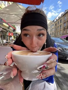 a woman holding a cup of coffee in front of her face