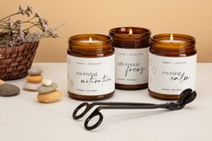 three candles, scissors and some rocks on a table