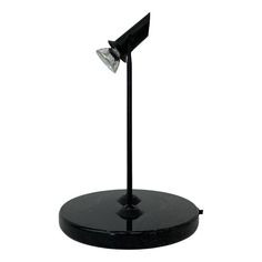 a black table lamp with a white light on it's head and two lights in the middle