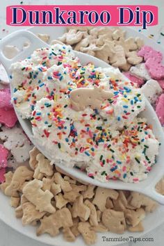 a spoon full of sprinkles and cookies on top of a white plate