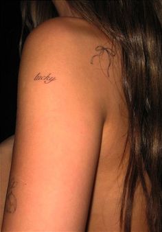 the back of a woman's shoulder with tattoos on her left arm and chest