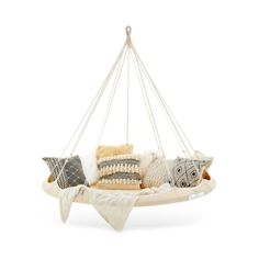 a hanging chair with pillows and blankets on the bottom, in front of a white background