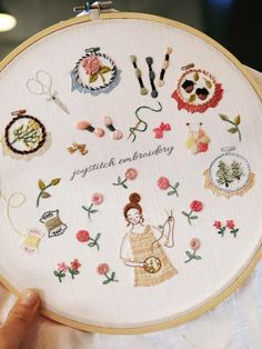 a person holding up a cross stitch embroidery