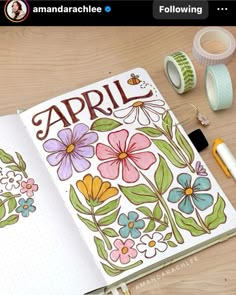 an open notebook with flowers and the word april written in large letters on it, surrounded by other items