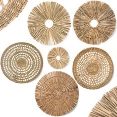 wicker plates and baskets are arranged on a white surface with the same pattern as they appear to be woven