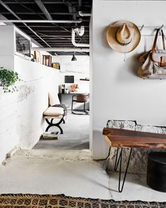 a room with some hats hanging on the wall and a bench in front of it