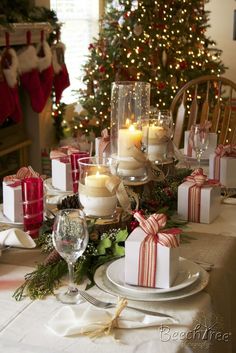 a christmas table setting with candles and presents