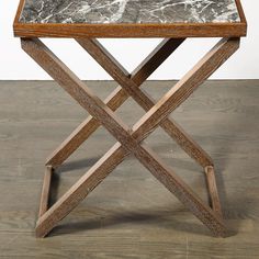 a wooden table with marble top sitting on a hard wood floor