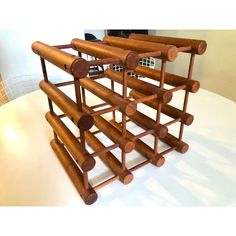 a wine rack made out of wood on top of a white table next to a wall