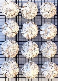 several cookies are on a cooling rack with powdered sugar