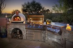 an outdoor bbq grill is lit up at night with candles on the counter and outside