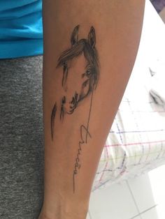 a woman's arm with a horse tattoo on the left side of her leg