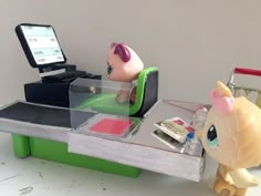 a table with an electronic device on it and a toy animal sitting at the top