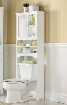 a white toilet sitting in a bathroom next to a cabinet