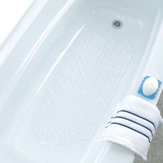 a white bath tub with a blue and white towel next to it