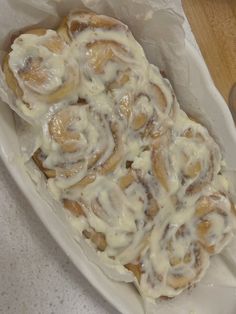 a white plate topped with cinnamon rolls covered in icing