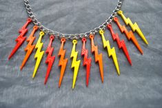 Red, orange and yellow lightning bolt pendants on a silver colour necklace. 16 inch silver colour necklace with a 2 inch extender chain Acrylic lightning pendants Lobster clasp For other  Lightning necklaces items click here: https://www.etsy.com/uk/shop/InfiniteRoseDesigns?ref=seller-platform-mcnav&section_id=23620397 Thank you for visiting, for more items from InfiniteRoseDesigns, go to my shop. https://www.etsy.com/uk/shop/InfiniteRoseDesigns?ref=seller-platform-mcnav Rainbow Dash Cosplay, Lightning Necklace, Star Lollipops, Yellow Lightning, Kawaii Sweets, Lightning Pendant, Thunder Bolt, Lightning Bolt Necklace, Pastel Earrings