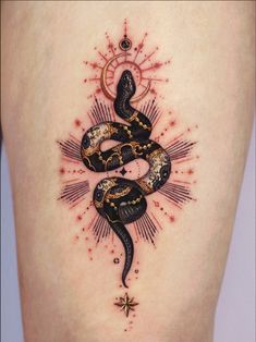 a tattoo on the back of a woman's thigh with a snake and sunburst