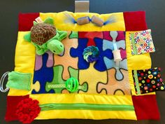 a stuffed animal is laying on top of a colorful piece of cloth with other items around it