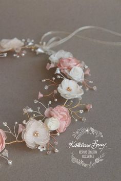 a close up of a flower headband on a table with pearls and flowers in it