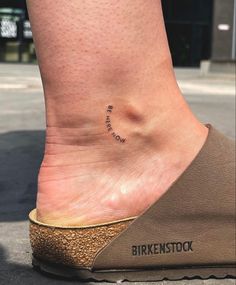 a person's foot with a small tattoo on it