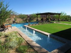 a backyard with a pool and water feature