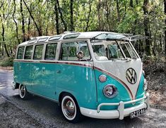 an old vw bus is parked on the side of the road in front of some trees